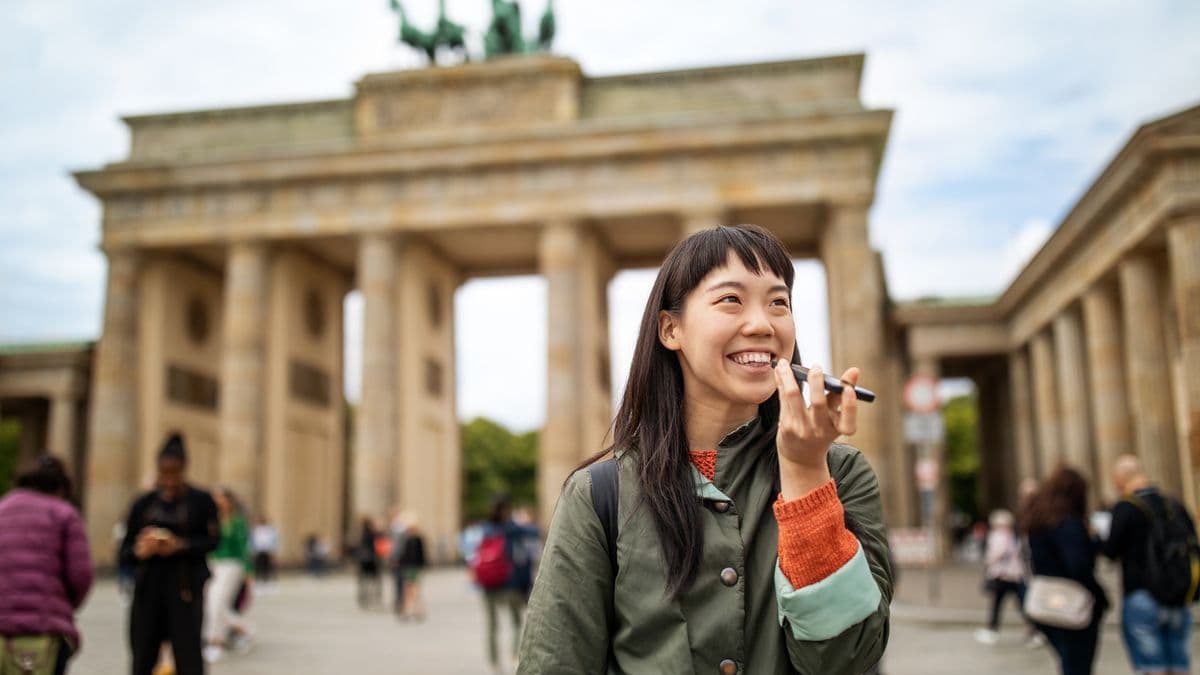 Woman talking on mobile phone against Brandenburg Gate