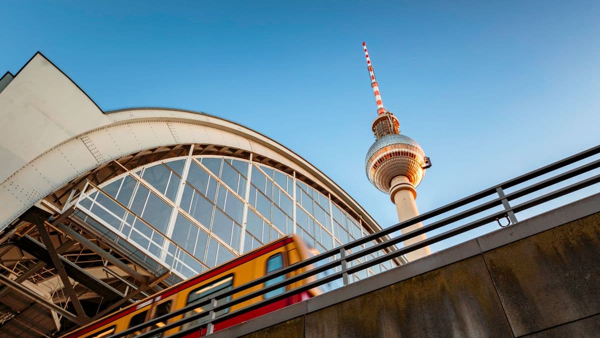 A train leaving Aleksanderplatz station in Berlin with the TV tower in the background.