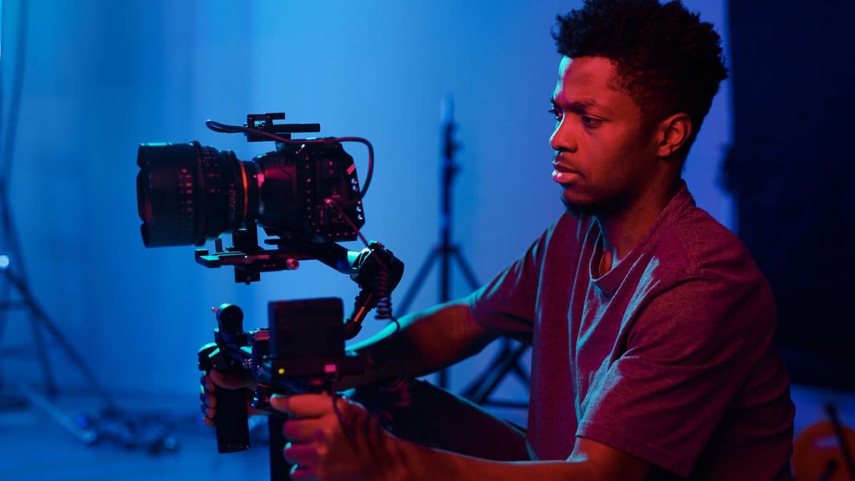 A young person operating a professional video camera in a studio.