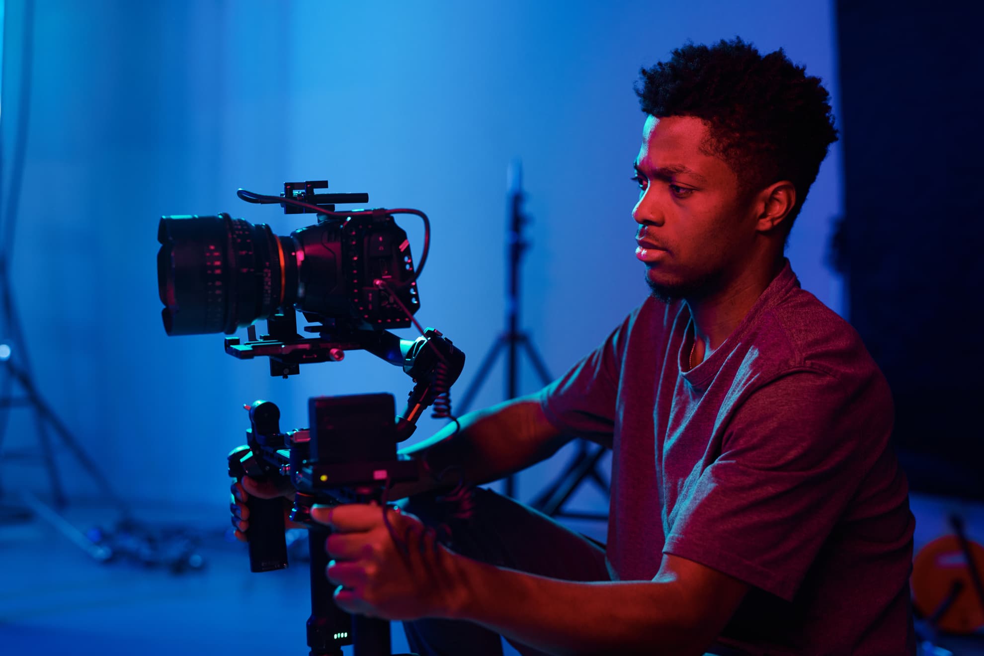 A young person operating a professional video camera in a studio.